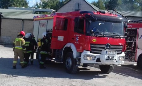 Strażacy przy samochodzie bojowym